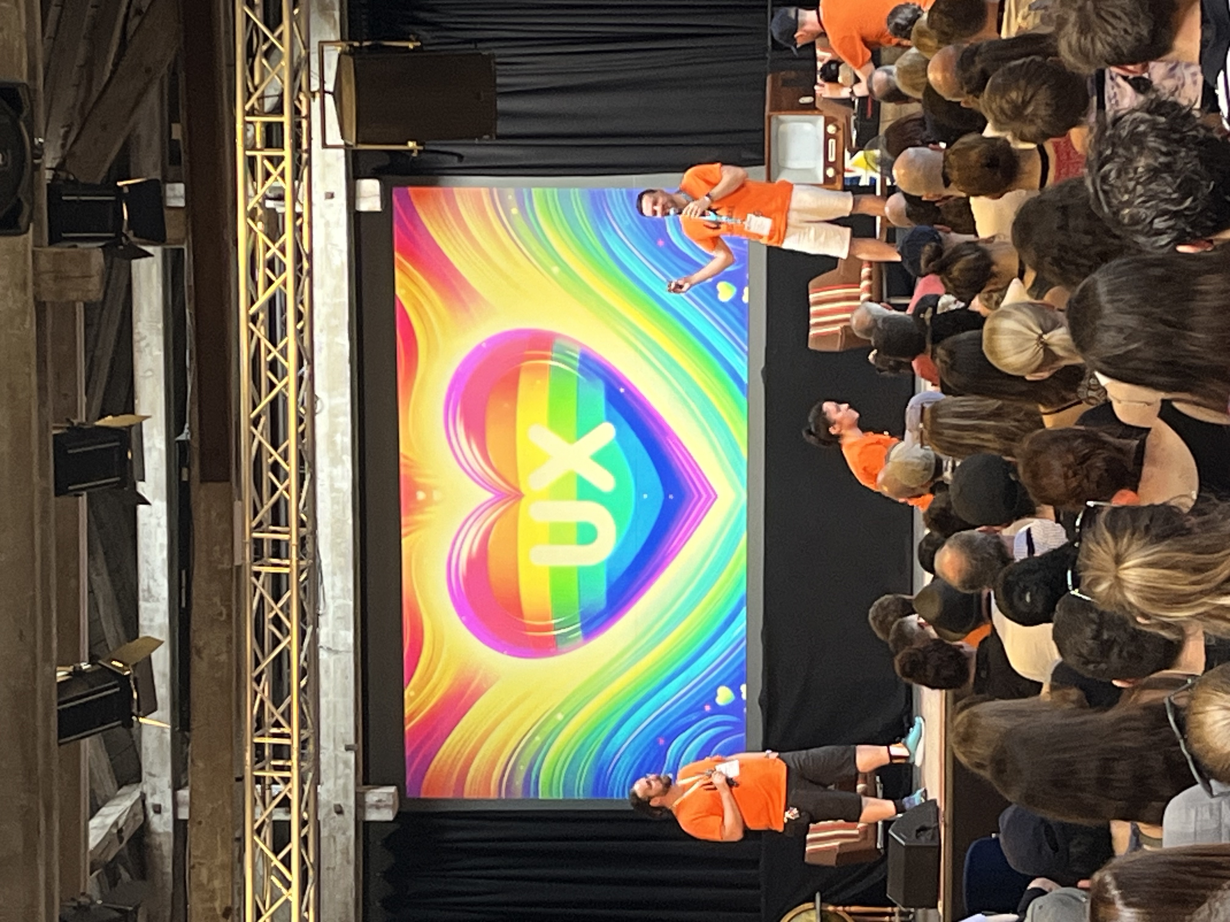Foto der Präsentation auf der Hauptbühne, das ein buntes Herz mit der Aufschrift UX in der Mitte zeigt
